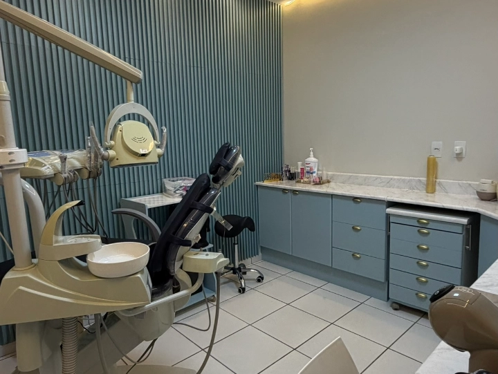 Sala clínica com cadeira e equipamentos odontológicos